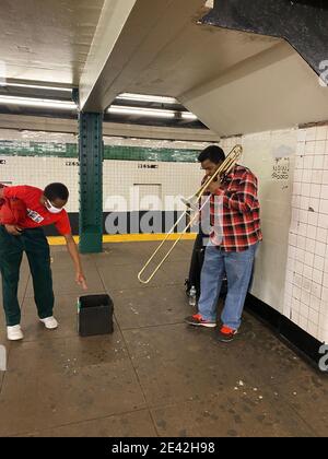 Man montre son appréciation d'un joueur de trombone dans la station de métro West 4th Street à Greenwich Village, New York City. Banque D'Images