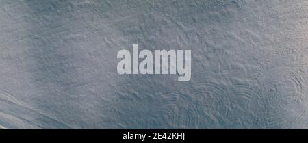 La texture de la neige blanche en hiver sur le terrain à partir de la hauteur d'un drone volant. Arrière-plan de la conception Banque D'Images