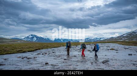 Groupe d'amis randonneurs qui traversent la rivière par Team Working Banque D'Images