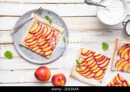 Délicieux dessert rafraîchissant, tartes de pâte feuilletée juteuse au fromage à la crème et arrosées de sucre en poudre sur fond de bois rustique Banque D'Images