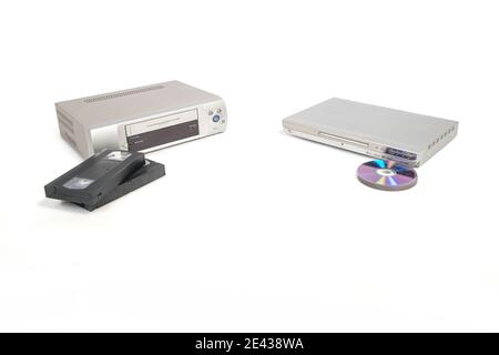 Lecteur vidéo et cassettes à côté d'un lecteur de dvd et dvd ou cd isolés sur fond blanc. Banque D'Images