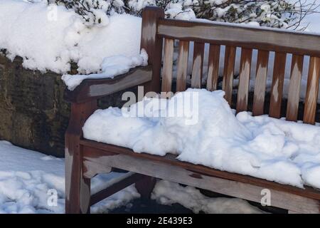 Un siège de jardin en bois recouvert de neige. Banque D'Images