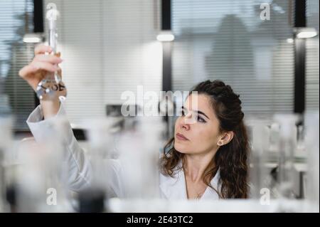 Adulte médecin ophtalmologiste dans le masque de protection vérifiant la vue de la patiente senior avec l'ophtalmoscope Banque D'Images