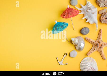 Coquillages, pierres et parasols sur fond jaune Banque D'Images