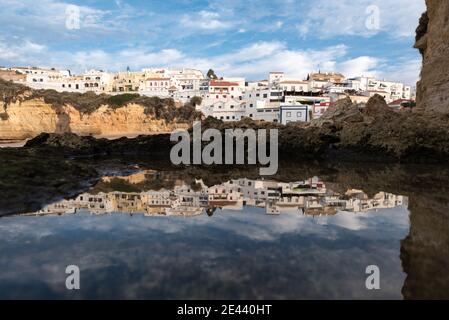 Plage de Carvoeiro avec bâtiment de village au sommet de la falaise La côte en Algarve Portugal Banque D'Images