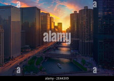 Coucher de soleil incroyable sur Chicago Riverwalk avec des ponts au-dessus de la rivière et façades en verre de bâtiments contemporains de plusieurs étages Banque D'Images