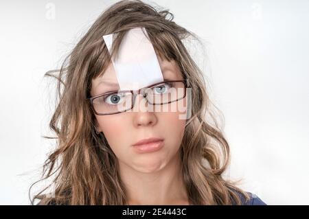 Portrait d'une femme drôle avec papier blanc collant vierge sur son front Banque D'Images