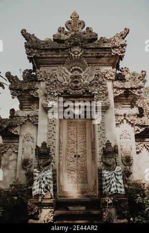 Extérieur à angle bas de l'entrée du palais historique hindou d'Ubud Ou Puri Saren Agung avec des statues traditionnelles situées à Bali En Indonésie Banque D'Images