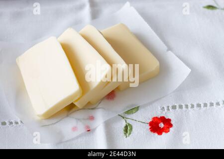 Des tranches de beurre et des bâtonnets aromatiques de cannelle pour préparation de pâtisserie placée sur la nappe de coton sur la table à la maison Banque D'Images