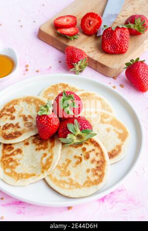 Gros plan de crêpes maison avec fraises fraîches servies sur l'assiette sur table pour un petit déjeuner sain Banque D'Images