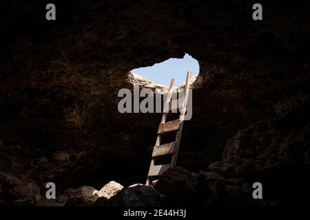Vue de l'intérieur d'une grotte avec des escaliers menant vers l'extérieur par un trou Banque D'Images