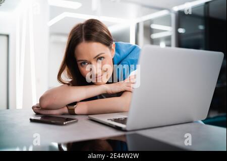 Portrait d'une femme caucasienne heureuse et réussie en tenue informelle regardant et souriant à l'appareil photo. Une femme attirante sur l'auto-isolation après Banque D'Images