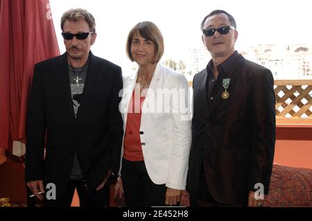 Johnny Hallyday, la ministre française de la culture Christine Albanel et le réalisateur Johnnie se présentent au 'café des Palmes' lors du 62e Festival international de Cannes, le 18 mai 2009. La ministre française de la Culture, Christine Albanel, honore la directrice de Hong Kong, Johnnie to, avec la médaille « Officier dans l'ordre national des Arts et des lettres ». Photo de Gorassini-Guignebourg/ABACAPRESS.COM Banque D'Images