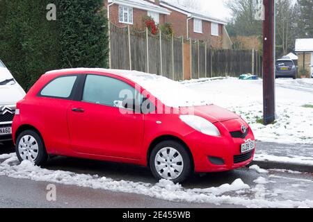 toyota prius rouge recouvert de neige garée sur le côté de la route Londres Banque D'Images