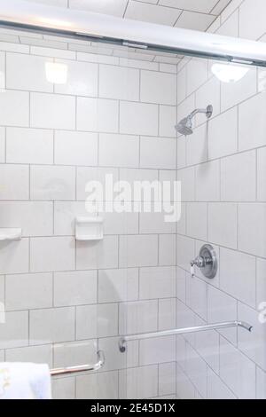 Salle de bains rénovée avec carrelage blanc en métro, douche avec porte vitrée Banque D'Images