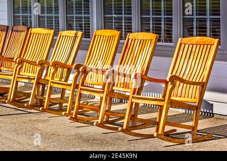 Fauteuils à bascule dans une rangée sur une véranda extérieure Banque D'Images