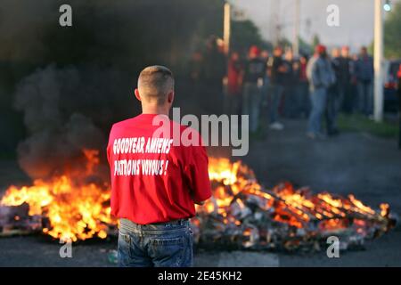 Les travailleurs de Goodyear tire & Rubber de l'usine de Dunlop, dans le nord de la France, à Amiens, se tiennent devant un blocus effectué avec des pneus en feu pour bloquer l'accès de leur usine lors d'une manifestation sur le site, le premier jour des actions d'une semaine pour protester contre ag Banque D'Images