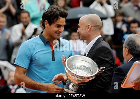 Roger Federer, de Suisse, reçoit le trophée de l'ancien joueur de tennis américain André Agassi après sa victoire lors du match final masculin du tournoi de tennis de l'Open de France au stade Roland Garros à Paris, le dimanche 7 juin 2009. La victoire donne à Federer 14 Grands slams, liant sa carrière victoires à l'américain Pete Sampras. Federer a remporté 6-1, 7-6 (7/1), 6-4. Photo de Henri Szwarc/ABACAPRESS.COM Banque D'Images