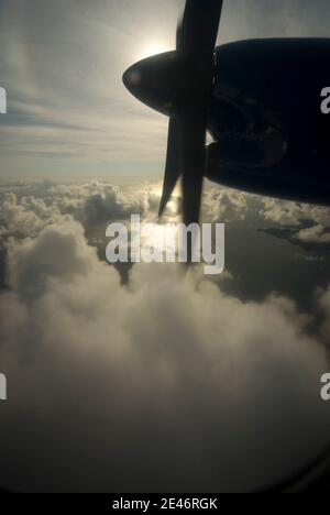 L'avion propulse sur l'aile contre un ciel nuageux et sur l'océan Banque D'Images