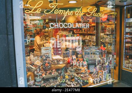 BRUXELLES, BELGIQUE - 15 octobre 2014 : photo d'un employé servant la fenêtre d'une boutique de chocolats et de sucrées dans une galerie urbaine de Bruxelles. Banque D'Images