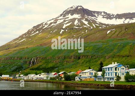 Vue sur les bâtiments et les maisons résidentielles donnant sur le fjord et les montagnes près de Seydisfjordur, Islande en été Banque D'Images