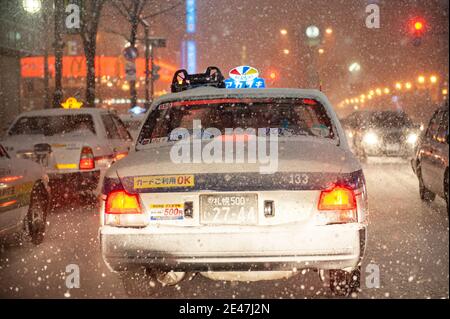 Les taxis japonais sont coincés dans la circulation lors d'une nuit enneigée. Banque D'Images