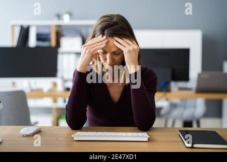 Femme décontractée avec mal de tête dans la vidéoconférence Banque D'Images
