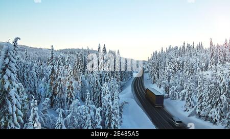 Circulation sur une autoroute à travers un col de montagne enneigé en hiver. Banque D'Images