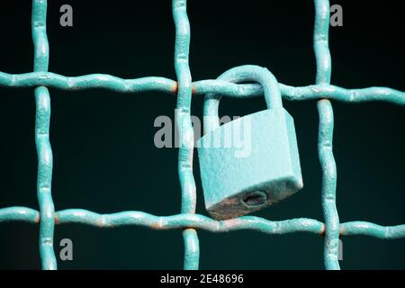 Cadenas sur une clôture métallique, peint en vert Banque D'Images