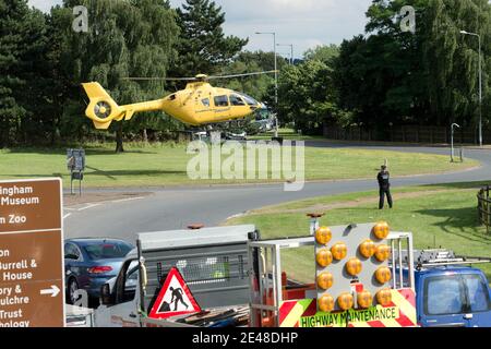 L'hélicoptère de sauvetage East Anglian Air Ambulance atterrit sur un rond-point de l'autoroute britannique pour transporter une personne blessée à l'hôpital. Banque D'Images