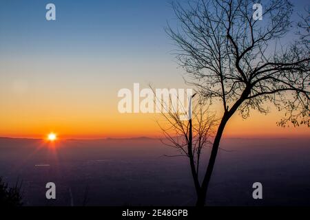 Panorama arbre silhouette en italie avec coucher de soleil.arbre silhoueté contre un soleil couchant. Assise, province de l'ombrie en arrière-plan Banque D'Images