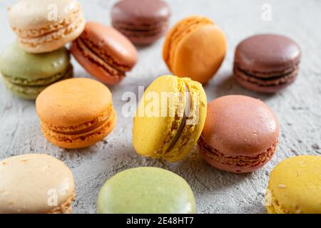 Macarons multicolores ou macarons - délicieux petits gâteaux français dans un mess sur une table grise, sélective Banque D'Images