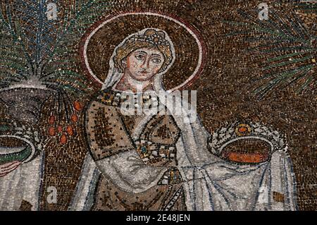 Somptueusement habillée et tenant une couronne de bijoux, l'une des 22 saintes chrétiennes féminines marche en procession. Détail de la mosaïque byzantine dans la Basilique di Sant’Apollinare Nuovo à Ravenne, Emilie-Romagne, Italie. La mosaïque a été créée dans les années 500 après JC, quelques années après que Ravenne a été capturée par l'Empire byzantin aux Ostrogoths. Banque D'Images
