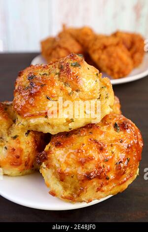 Gros plan pile de savoureux biscuits à l'ail et à l'herbe avec de l'aspect flou Poulets frits en arrière-plan Banque D'Images