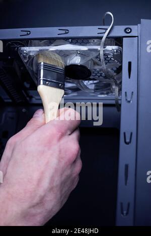 Nettoyage du ventilateur sale du processeur de l'ordinateur de bureau de la poussière à l'aide d'une brosse spéciale. Banque D'Images