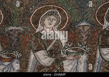 Visage avec les yeux fixés : une des 22 saintes chrétiennes somptueusement habillées marche en procession. Détail de la mosaïque byzantine, créée dans les années 500 après JC, dans la Basilique di Sant’Apollinare Nuovo à Ravenne, Emilie-Romagne, Italie. Banque D'Images