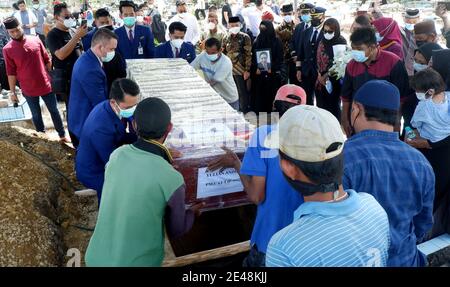 Bangka Belitung, Indonésie. 22 janvier 2021. Les pallbearers abaissent un cercueil portant les restes de Yulian Andhika, un steward qui a péri à bord de la Sriwijaya Air SJ 182 qui s'est écrasée dans la mer de Java quelques minutes après le décollage de Jakarta le 9 janvier, lors de funérailles au cimetière public Srimenanti sur l'île indonésienne de Bangka Belitung le 22 janvier. 2021. (Photo par Hairul Ashter/INA photo Agency/Sipa USA) crédit: SIPA USA/Alay Live News Banque D'Images