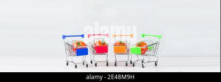 Prise de tomates mûres savoureuses dans un panier ou un chariot sur fond blanc. Concept de commerce de tomates. Concept d'achat en ligne. Taille de la bannière. Copier l'espace. Banque D'Images