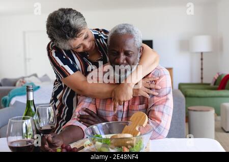 Couple afro-américain senior assis à table dîner et se serrer à la maison Banque D'Images
