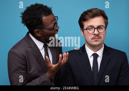 Un homme d'affaires mûr et en colère qui s'est trompé sur son jeune employé, Studio shot. Banque D'Images