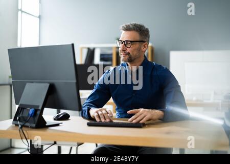 Homme d'affaires utilisant un ordinateur professionnel dans un bureau ou un lieu de travail Banque D'Images