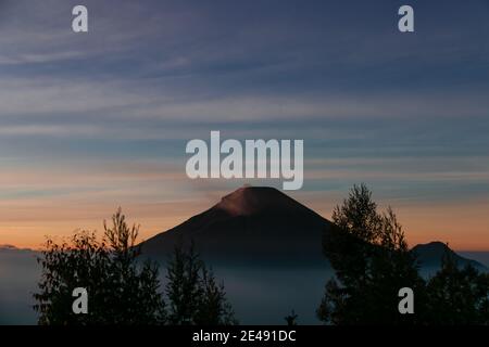 Vue sur les montagnes de Sindoro avec une mer de ​​clouds dans le centre de Java, Indonésie du haut tôt le matin Banque D'Images