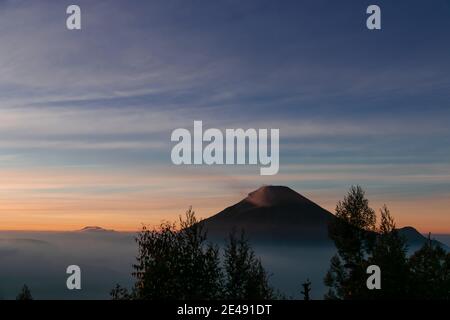 Vue sur les montagnes de Sindoro avec une mer de ​​clouds dans le centre de Java, Indonésie du haut tôt le matin Banque D'Images