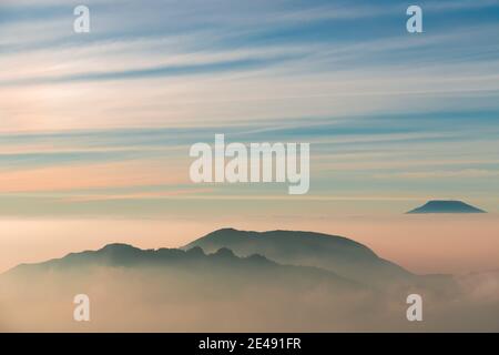 Vue sur les montagnes de Sindoro avec une mer de ​​clouds dans le centre de Java, Indonésie du haut tôt le matin Banque D'Images