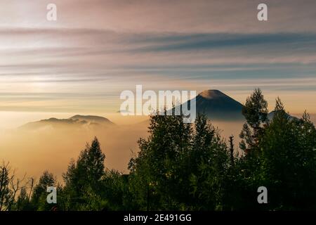 Vue sur les montagnes de Sindoro avec une mer de ​​clouds dans le centre de Java, Indonésie du haut tôt le matin Banque D'Images