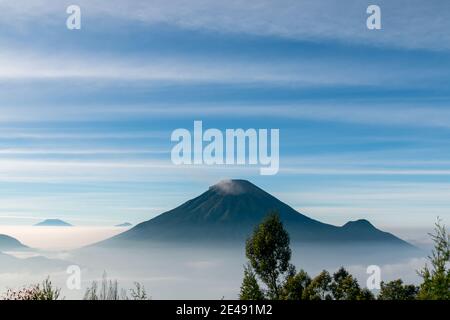 Vue sur les montagnes de Sindoro avec une mer de ​​clouds dans le centre de Java, Indonésie du haut tôt le matin Banque D'Images