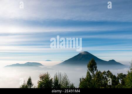 Vue sur les montagnes de Sindoro avec une mer de ​​clouds dans le centre de Java, Indonésie du haut tôt le matin Banque D'Images