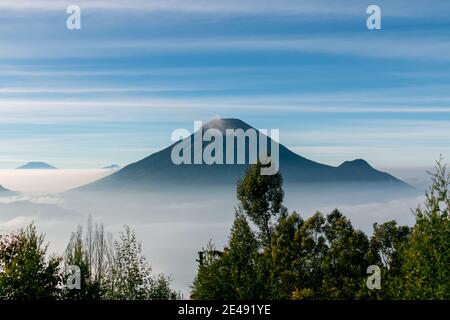 Vue sur les montagnes de Sindoro avec une mer de ​​clouds dans le centre de Java, Indonésie du haut tôt le matin Banque D'Images