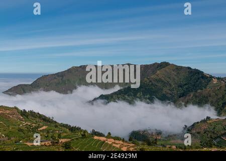 Vue sur les montagnes de Sindoro avec une mer de ​​clouds dans le centre de Java, Indonésie du haut tôt le matin Banque D'Images