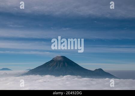 Vue sur les montagnes de Sindoro avec une mer de ​​clouds dans le centre de Java, Indonésie du haut tôt le matin Banque D'Images